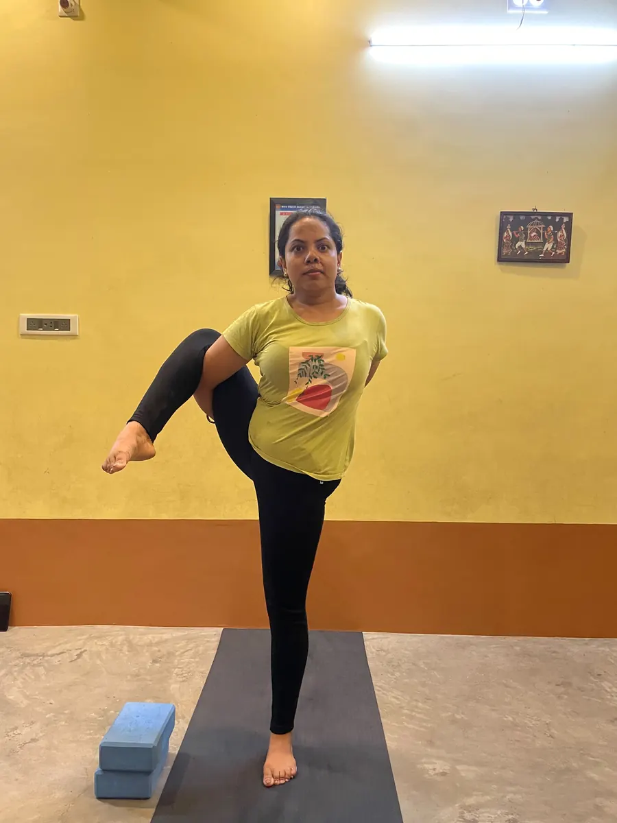 Student balancing on one leg while holding the other foot out to the side