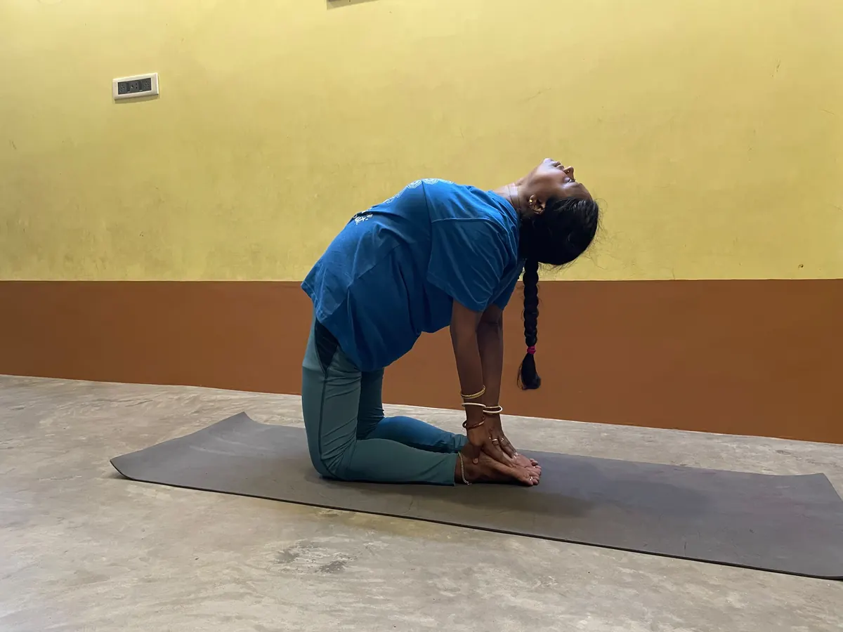 Student arching back into a deep camel pose on the mat