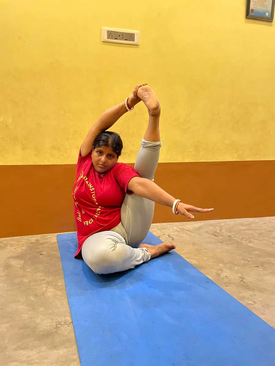 Student twisting into an advanced seated compass pose